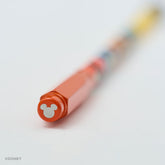 A close-up of a Blackwing red pencil point guard featuring a silver Mickey Mouse silhouette, shown on a clean white background with the rest of the pencil blurred due to a shallow depth of field.