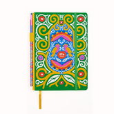 A hardcover notebook with a vibrant green cover decorated with a colorful Frida Kahlo spiral, bird, and floral illustration, featuring a green elastic closure band and a yellow bookmark ribbon with a matching pencil in the pencil holster.
