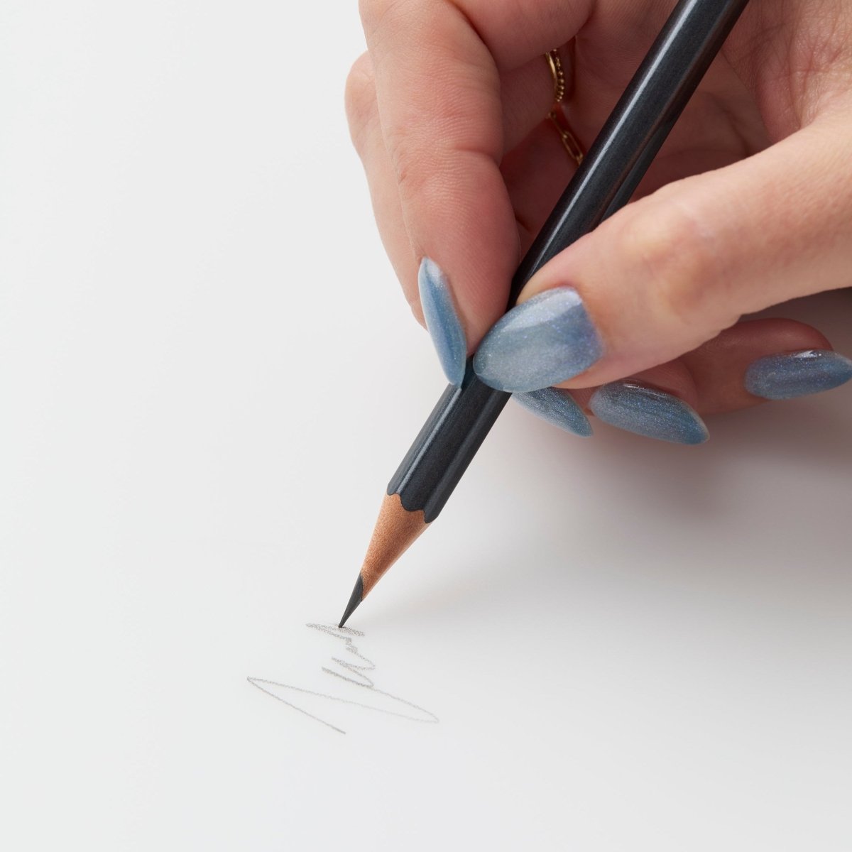 woman's hand scribbling with blackwing 602 pencil 