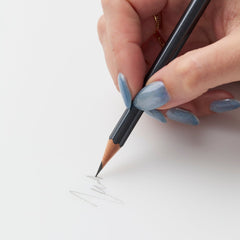 woman's hand scribbling with blackwing 602 pencil 