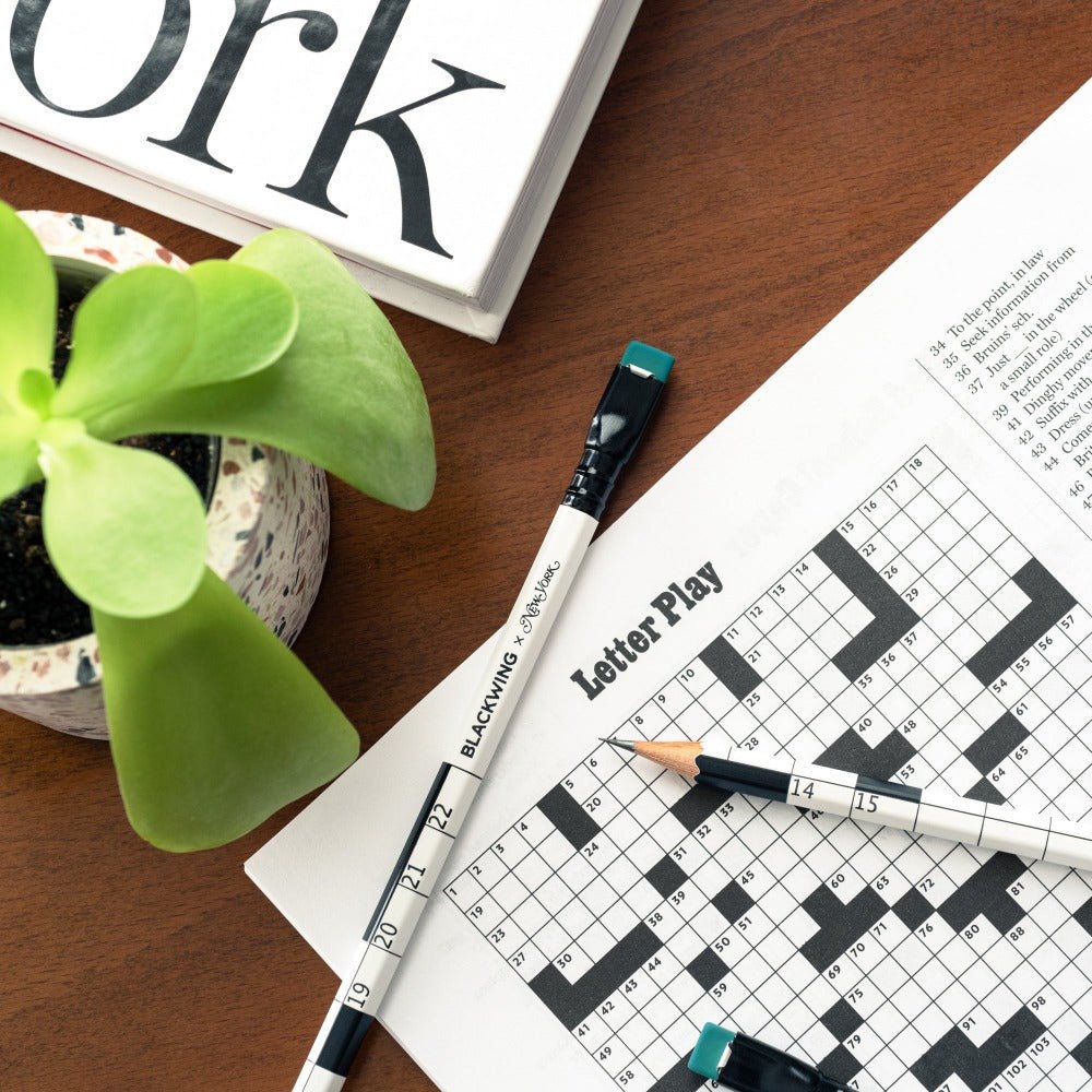 Blackwing x New York Magazine Crossword Puzzle Pencil sitting on a table with a crossword and plant