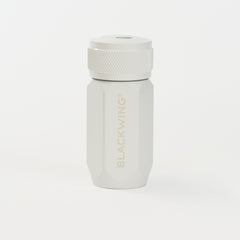 A white pencil sharpener, featuring the brand name 'BLACKWING' subtly printed on the front, set against a seamless white background.