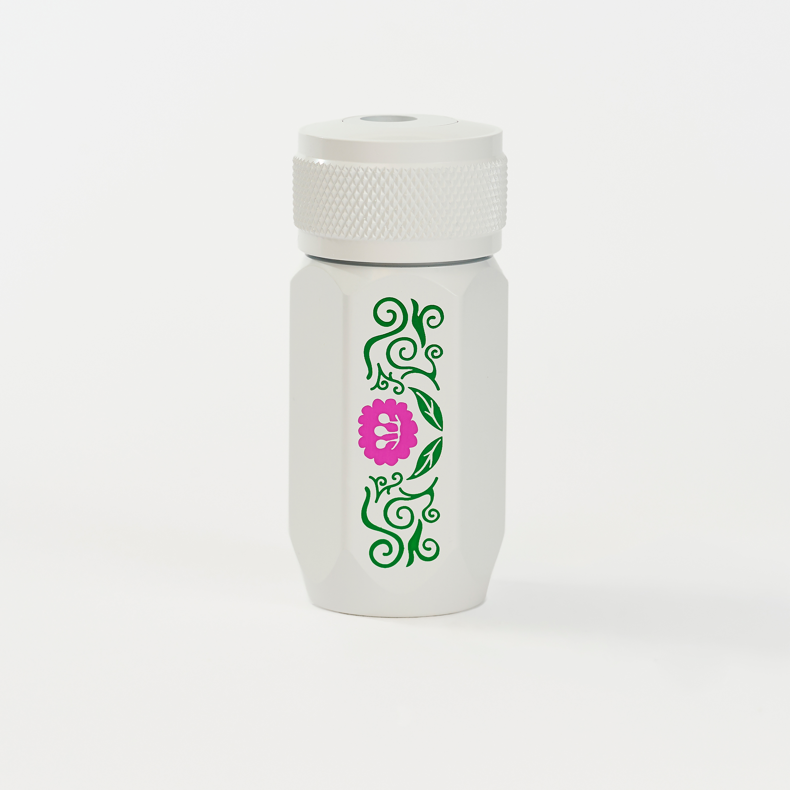 A white Blackwing one-step sharpener  featuring a green vine pattern and a pink flower graphic on the side.
