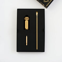 Blackwing x Lord of the Rings gold sharpener, gold point guard, and gold pencil in a black package on a white background