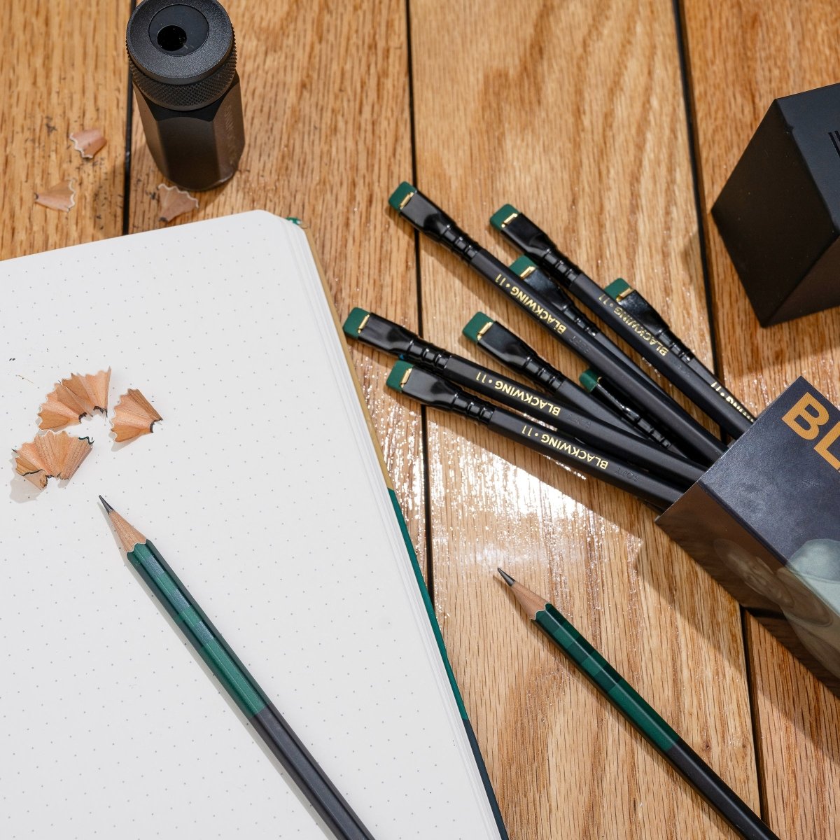 Blackwing Volume 11 Bill Russell Pencils and Notebook on a wood floor