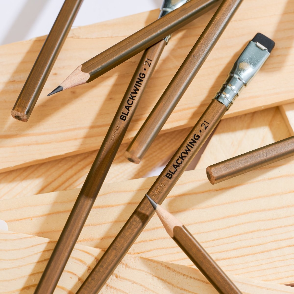 Blackwing Volume 21 pencils scattered on a wood background