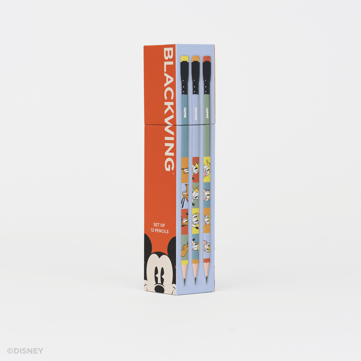 A boxed set of pencils standing upright on a clean white background. The packaging is bright red on the left with the word BLACKWING in large white letters and a Mickey Mouse face at the bottom, while the right side is light blue and shows the pencil barrels with cartoon graphics.