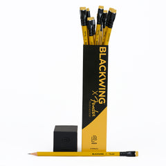 A set of 12 Blackwing x Fender Telecaster pencils in black and yellow packaging, shown with pencils popping out the top and a loose pencil lying horizontally at the bottom on a white background.
