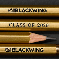 Gold pencils with 'Blackwing' branding and 'Class of 2026' black imprint text on a dark background