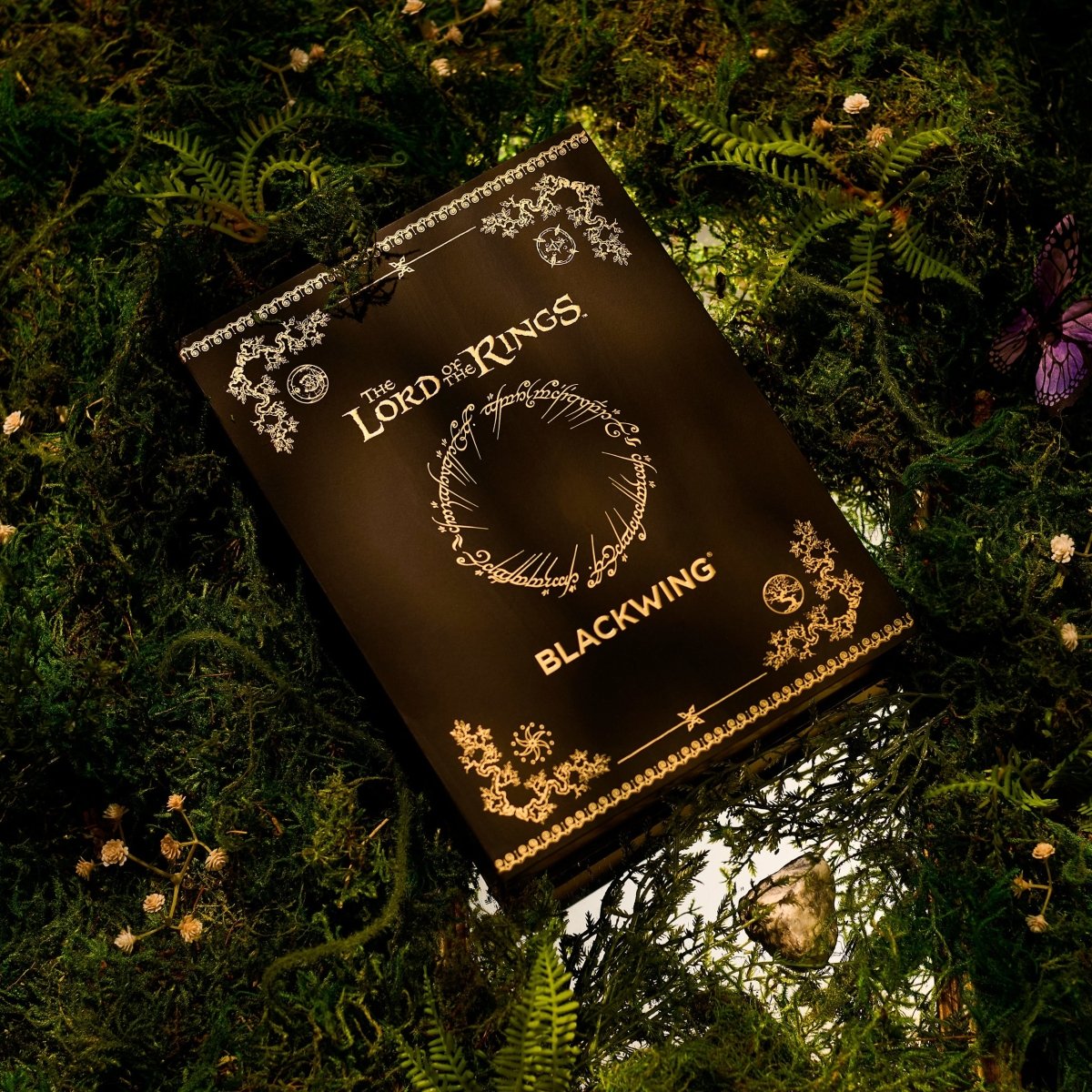 Black box with 'The Lord of the Rings' lettering and gold imprint design on top of greenery