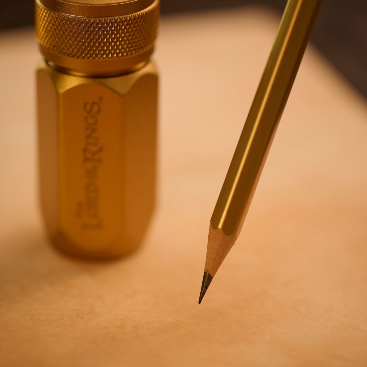 sharpened gold pencil next to a gold Lord of the Rings sharpener