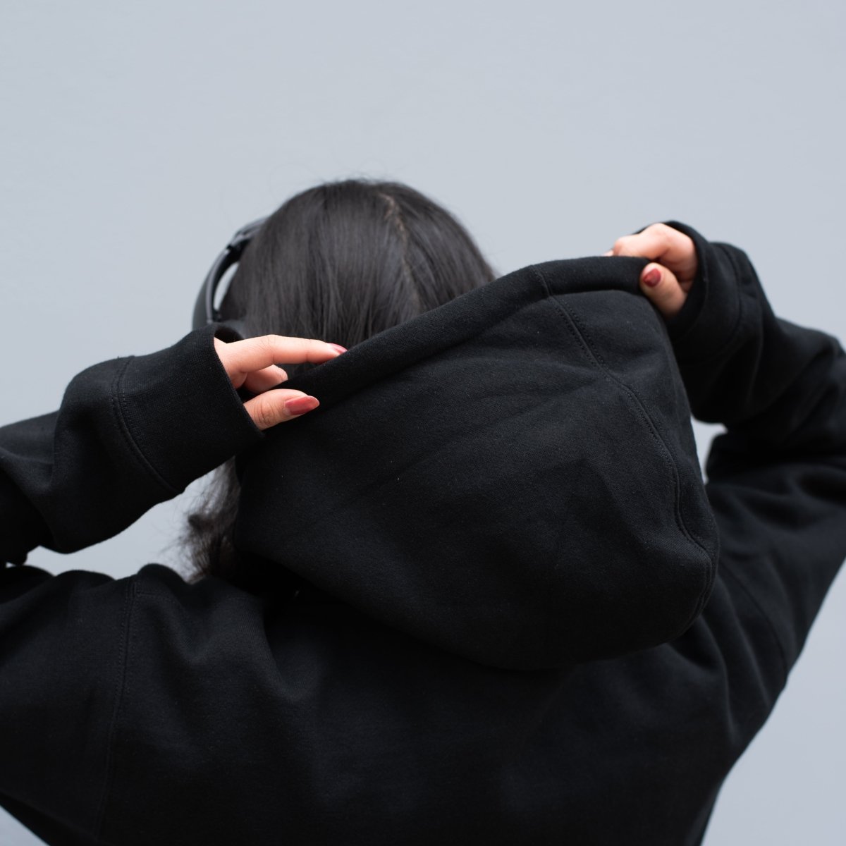 Person wearing a black hoodie with their back to the camera 