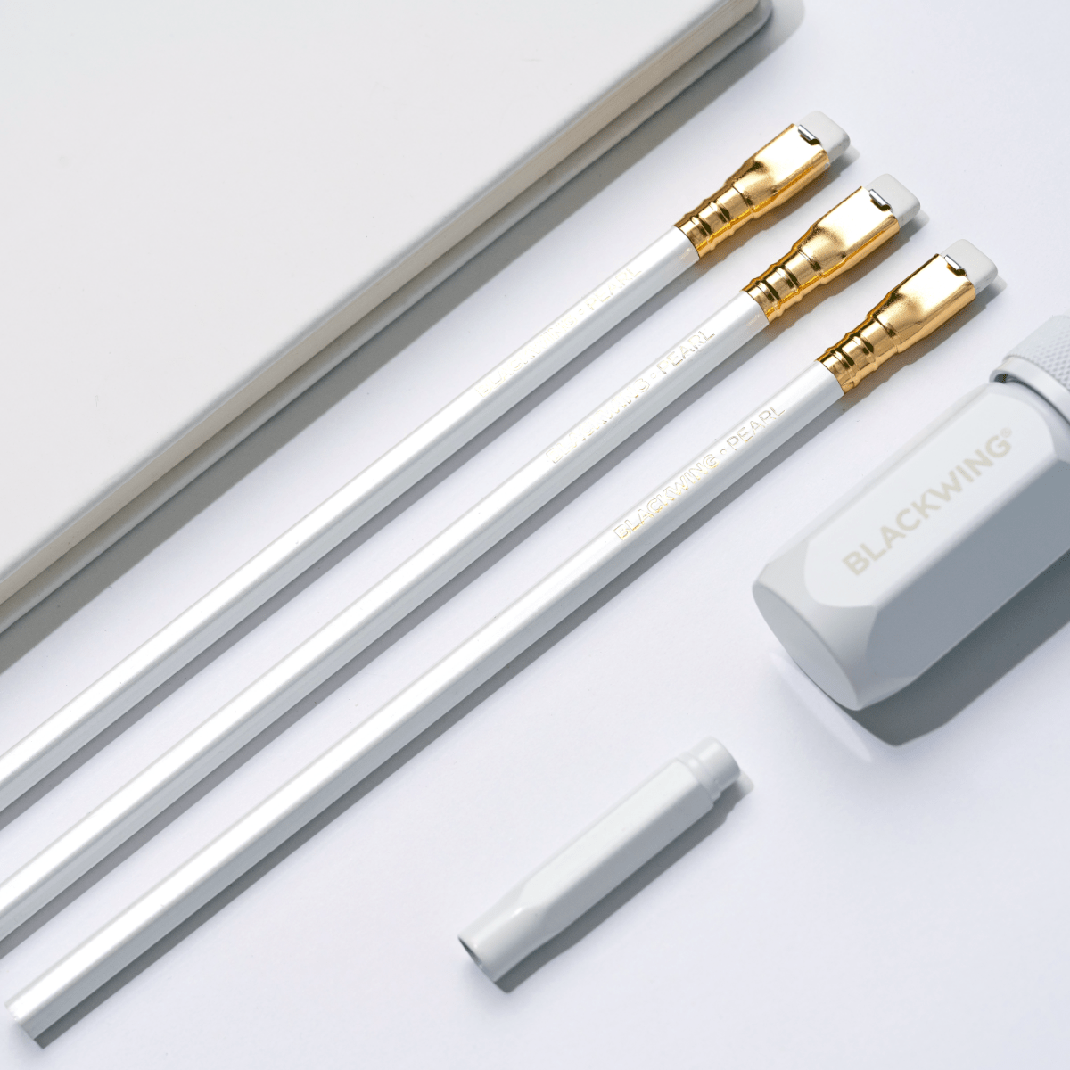 Blackwing white one-step sharpener, white pencil guard, pearl pencils, and white slate notebook