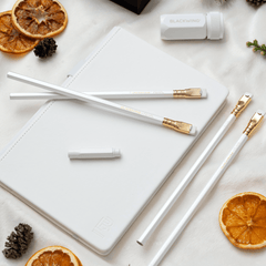 Blackwing winter notebook essentials set includes a white one-step sharpener, white pencil guard, 4 pearl pencils, and a white slate notebook