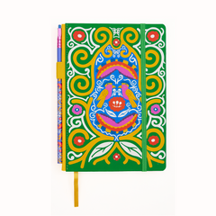A hardcover notebook with a vibrant green cover decorated with a colorful Frida Kahlo spiral, bird, and floral illustration, featuring a green elastic closure band and a yellow bookmark ribbon with a matching pencil in the pencil holster.