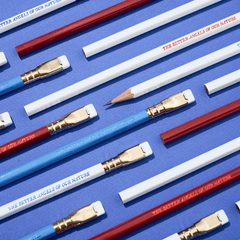 pencils that say 'THE BETTER ANGELS OF OUR NATURE' in red, white, and blue colorways arranged on a blue background