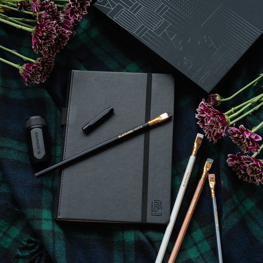 Blackwing Notebook Essentials Set includes a black slate notebook, 4 core pencils, a black pencil point protector, and a black one-step sharpener