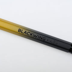 Blackwing Volume 458 gradient pencil with gold and black barrel, black imprint, and black ferrule