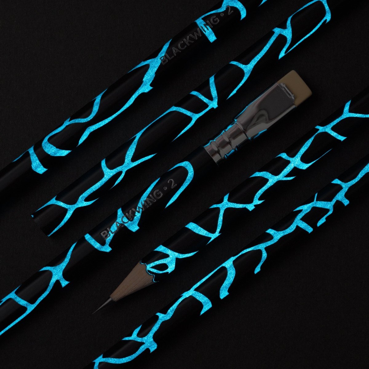  Blackwing Volume 2 pencil, black barrel with cracked blue design that glows in the dark