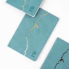Gold imprint of the California coast on a Blackwing 840 clutch notebook.